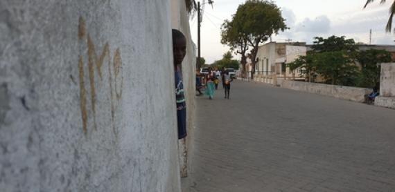 Pessoa a olhar para a rua por detrás de um muro