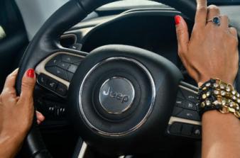 Mãos femininas a segurar volante de carro